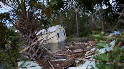 A displaced building alongside flooding littered with debris in Horseshoe Beach. AP