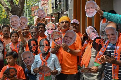 Bharatiya Janata Party workers and supporters with masks of Indian Prime Minister Narendra Modi gather during a road rally in Bengaluru. AFP