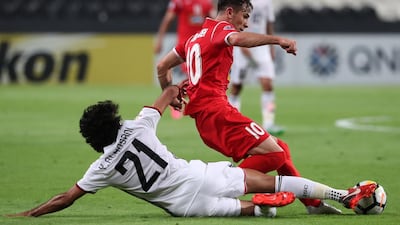 Al Jazira's Yaqoub Al Hosani, left, and Farshad Ahmadzadeh of Persepolis vie for the ball during their Asian Champions League game at Mohammed bin Zayaed Stadium in Abu Dhabi. Karim Sahib / AFP