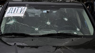 A sign saying 'children' on the windscreen of a car with bullet holes in Irpin on April 19. AFP