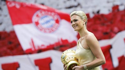 Germany's three times alpine skiing Olympic champion Maria Hofl-Riesch brings in the DFB-Pokal (German Cup) trophy before the cup final between Bayern Munich and Borussia Dortmund on Saturday. Fabrizio Bensch / Reuters / May 17, 2014