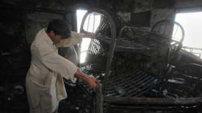 Niaz Muhammed, from Pakistan, picks through the twisted remains of his bed.