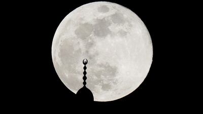 The full Moon rises over a mosque minaret in Amman, Jordan. Reuters