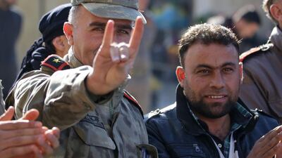 A man wearing a Turkish officer's uniform flashes the Grey Wolves sign, during a demonstration in support of Turkey in the Syrian town of Bizaa, north of Aleppo. AFP