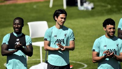 Naby Keita, Takumi Minamino, and Alex Oxlade-Chamberlain singing Happy Birthday. Getty