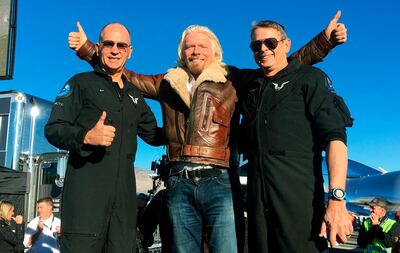 Richard Branson, centre, celebrates with pilots Rick “CJ” Sturckow, left, and Mark “Forger” Stucky, right. AP Photo