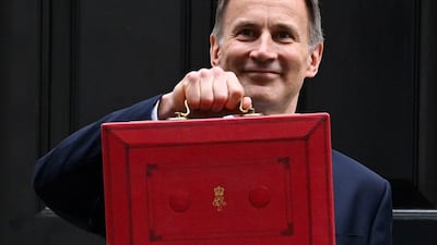 Jeremy Hunt leaves No 11 Downing Street with the red budget box on Wednesday. AFP