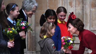 Britain's Catherine, Duchess of Cambridge, right, receives flowers from a child after the annual Commonwealth Service at Westminster Abbey. EPA