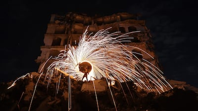 A Displaced Palestinian plays with fireworks after breaking his fast, outside a damaged building at the Jabalia refugee camp in the northern Gaza Strip, during the Muslim holy fasting month of Ramadan, on February 23, 2026. (Photo by Omar AL-QATTAA / AFP)