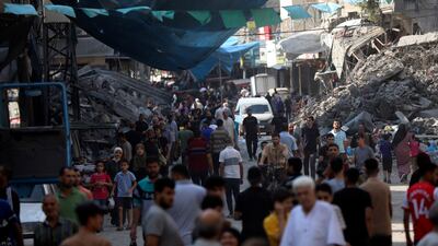 Palestinians walk in the street market of Jabaliya refugee camp, northern Gaza Strip, after an Israeli air strike. AP