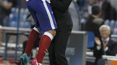 Atletico Madrid's French striker Antoine Griezmann, left, jumps onto coach Diego Simeone after scoring against Malmo in Atletico Madrid's 5-0 win in the Champions League on Wednesday night in Madrid. Kiko Huesca / EPA