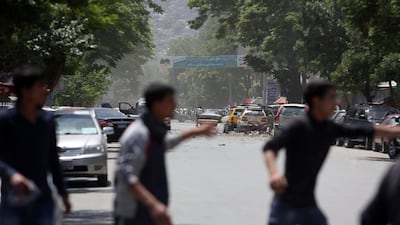 Afghans run from the site of a suicide attack, in the center of Kabul, Afghanistan on May 9, 2018. Three suicide bombers struck two police stations in Afghanistan's capital on Wednesday, wounding at least six people, officials said. Rahmat Gul / AP
