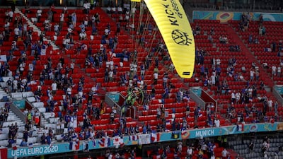 The paraglider flies over fans before landing on the pitch. AP Photo