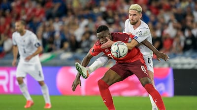Switzerland's Denis Zakaria, left, fights for the ball against Italy's Jorginho. AP