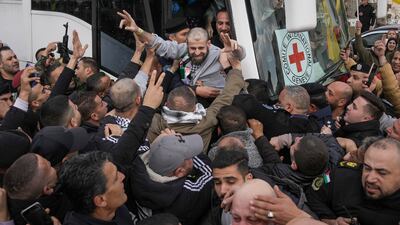 Palestinians are greeted by a crowd as they exit a Red Cross bus in the occupied West Bank city of Ramallah on February 1, after being released from Israeli prisons as part of a ceasefire agreement between Israel and Hamas. AP