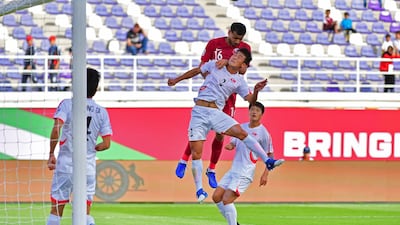 Qatar midfielder Boualem Khoukhi competes for a header against North Korea defender Chol Bom Kim. AFP
