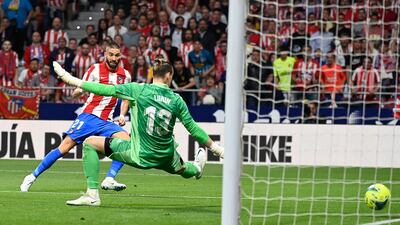 Atletico Madrid's Belgian midfielder Yannick Carrasco shoots at Real Madrid's Ukrainian goalkeeper Andriy Lunin. AFP