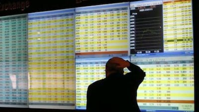 An investor watches price movements on an electronic board at the Amman Stock Exchange on January 31, 2011. Ali Jarekji / Reuters