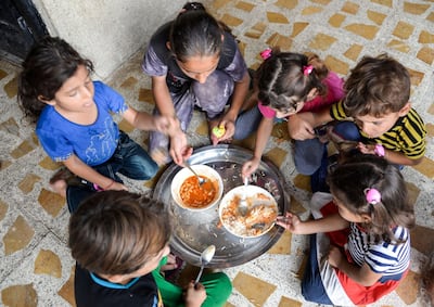 Grandchildren of 61-year-old Iraqi matriarch Sana Ibrahim share a meal in their family home in the northern city of Mosul. AFP