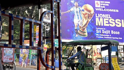 Commuters cross promotional posters of Inter Miami's Argentine forward #10 Lionel Messi, on the eve of his visit, in Kolkata. AFP