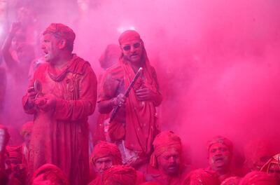 Men daubed in colours sing religious hymns as they celebrate Holi inside a temple in the town of Barsana in north India. Reuters