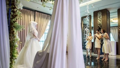 A bride is photographed by friends on her wedding day at the Al Meroz hotel in Bangkok. Thailand has seen an influx of visitors from Muslim countries as part of its strategy to diversify its visitor profile. Roberto Schmidt / AFP Photo