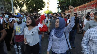 People hold Lebanese flags and chant as they mark the first anniversary of anti-government protests. Getty Images