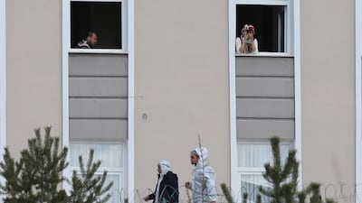 Turkish citizens look out from windows in Ankara after being quarantined to prevent the spread of coronavirus after returning from Saudi Arabia, where they took part in the Umrah pilgrimage. EPA