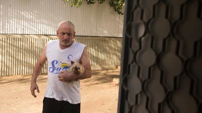 A man carries his dog to safety as he hears sirens warn of incoming rocket strikes from the Gaza Strip on May 17, in Ashdod, Israel. Getty