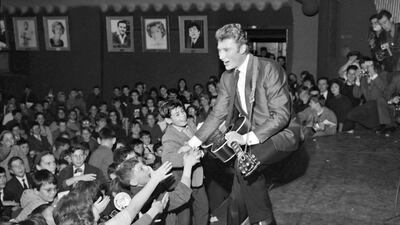 (FILES) In this file photo taken on December 13, 1962 French singer Johnny Hallyday performs a concert at the Olympia hall in Paris. France's best-known rock star Johnny Hallyday has died aged 74 after a battle with lung cancer, his wife Laeticia told AFP on December 6, 2017. / AFP PHOTO / -