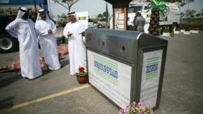 A recycling bin that uses solar power is displayed.