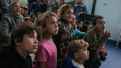 Refugee children at a refugee camp in Lebanon watch a magic show in Syria. Courtesy Magic for Smiles