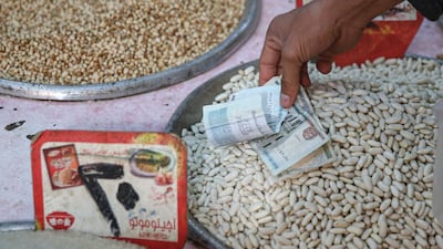 A customer hands over Egyptian pound banknotes for a purchase at Al Monira food market in the Imbaba district of Giza, Egypt. Bloomberg