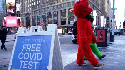 Mascots walk past a sign for Covid-19 tests in New York City. AFP