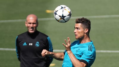 Real Madrid forward Cristiano Ronaldo heads the ball in training as Zinedine Zidane looks on. Sergio Perez / Reuters