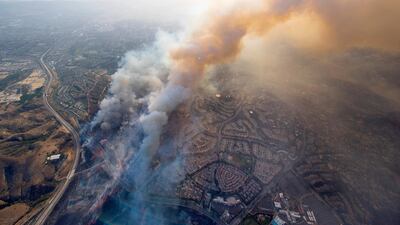 A wildfire moves closer to homes in Tustin. Cindy Yamanaka / The Orange County Register via AP