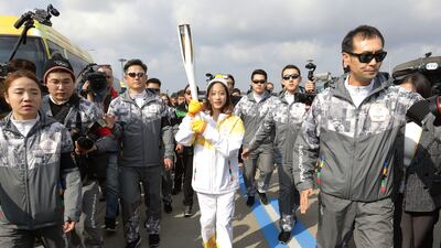First torch bearer, South Korean figure skater You Young runs as she hold the PyeongChang 2018 Winter Olympics torch during a torch relay on Wednesday in Incheon, South Korea. Chung Sung-Jun / Getty Images