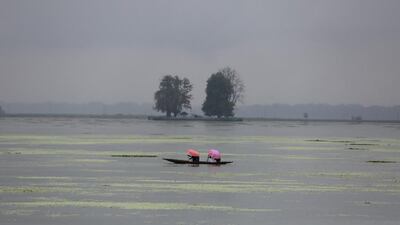 Kashmiri girls row a boat as they hold umbrella to protect themselves from the rain on Dal Lake in Srinagar, India. Farooq Khan / EPA