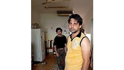 Three men stand in a nearly empty room in a building scheduled to be demolished.