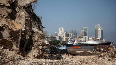 A cargo ship sits anchored behind the destroyed Silo at Beirut's port on July 13, 2021, almost a year after the August 4 massive explosion that killed more than 200 people and injured scores of others. AFP