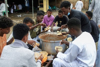 Volunteers provide meals at a displacement camp in Gedaref city. AFP