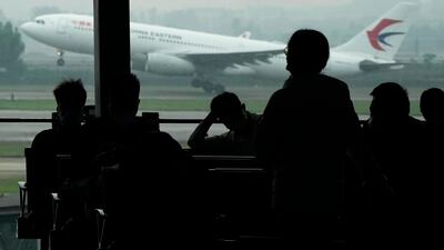Passengers wait for their flight as a China Eastern flight takes off from the runway of Baiyun Airport on Friday, March 25, 2022, in Guangzhou province, southern China. AP