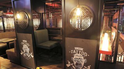 On the upper floor, a temporary tattoo booth overlooks the bowling alley.