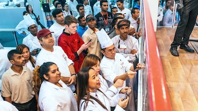 The audience reacts as an ice sculpture falls over during a competition at Gulfood.