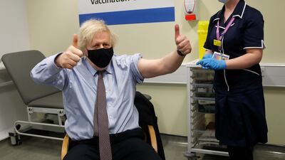 Mr Johnson gestures after receiving the first dose of AstraZeneca vaccine at St Thomas's Hospital on March 19, in London.