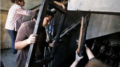 Egyptians Christians remove objects from the damaged Virgin Mary church in Cairo yesterday, after clashes between Muslims and Christians.
