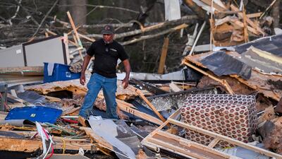 James Ezell, a survivor, looks through the remains of a destroyed home in Wren. EPA