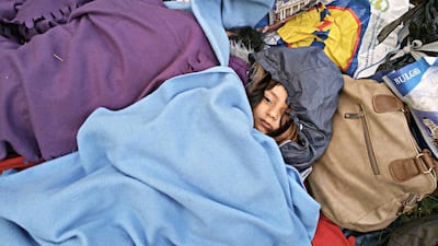 Fazili's daughter Zahra sleeps among their belongings on the Balkan route. Courtesy Old Chilly Pictures