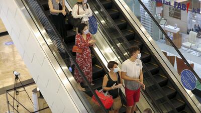 Shoppers wear face masks at Dubai's Mall of the Emirates. Contactless check-out is being expedited across the GCC due to social distancing measures. Pawan Singh / The National