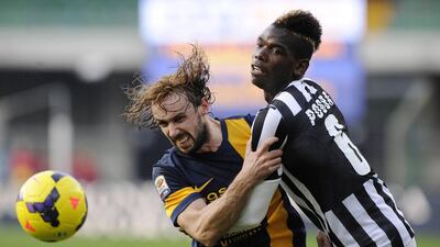 Juventus' Paul Pogba, right, fights for an aerial ball with Hellas Verona's Marco Donadel. Giorgio Perottino / Reuters